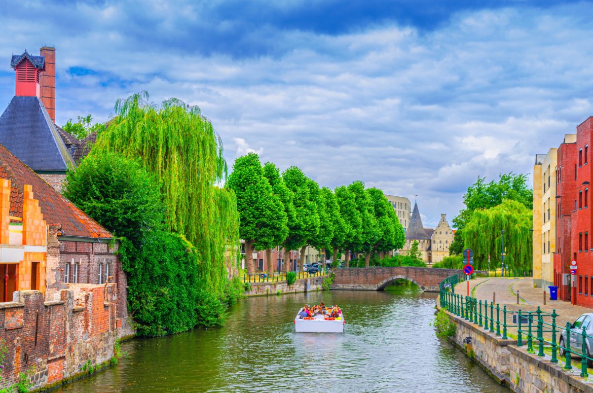 Ghent,Cityscape,,Brick,Buildings,And,Trees,Plants,On,Bank,Of
